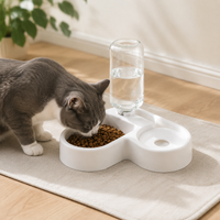 Cat eating from a white automatic food and water bowl