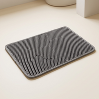 Double-layer cat litter trapping mat on a warm neutral studio background