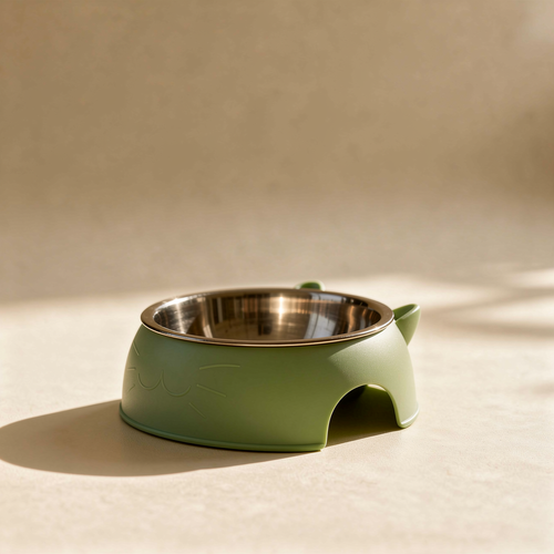 Green elevated cat-ear stainless steel bowl on a warm natural background