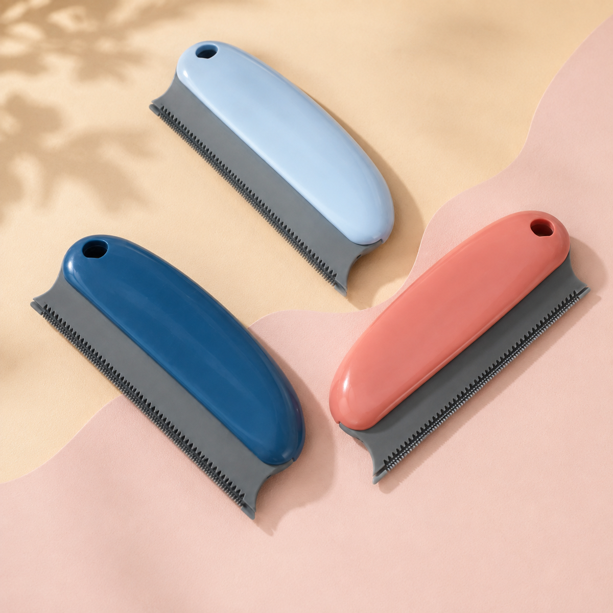 Reusable pet hair remover scraper shown in dark blue, light blue and coral color variations